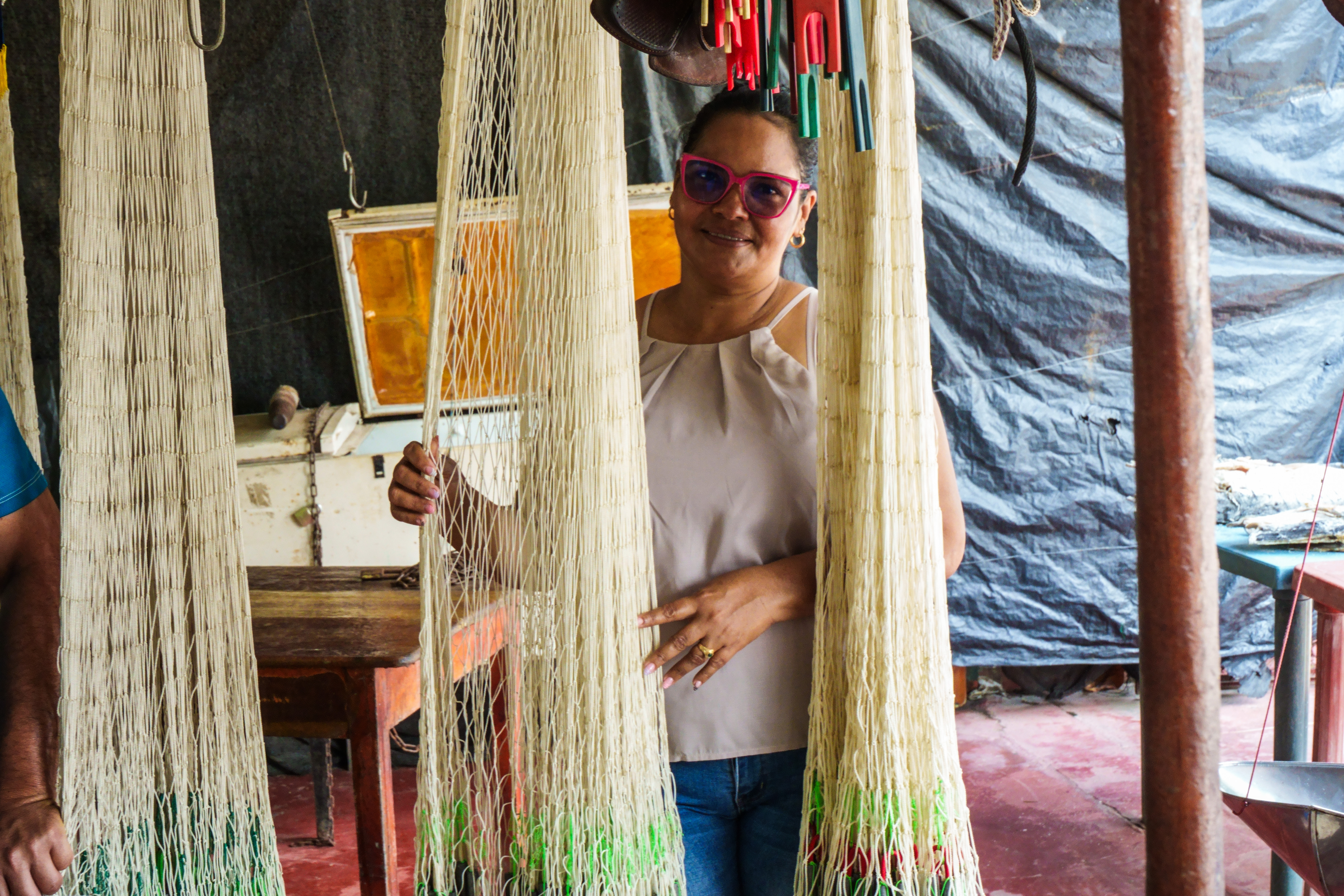 Mujer artesana entre hamacas tejidas a mano en un proyecto de fortalecimiento cultural